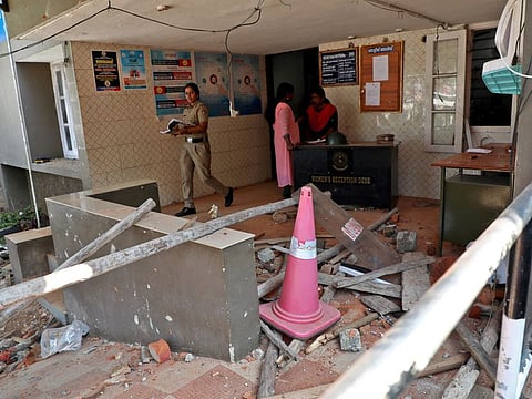 A police officer walks past rubble after a clash with protesters at a police station near the proposed Vizhinjam Port in the southern state of Kerala, India, November 28, 2022.