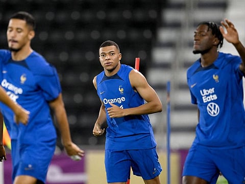 France's forward Kylian Mbappe (centre) looks on during a training session at Jassim-bin-Hamad Stadium in Doha.