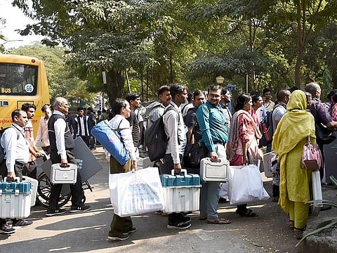 Polling officials carrying Electronic Voting Machines (EVMs) and other necessary inputs required for the Gujarat Assembly Election, at Katargam Balaashram school ground, in Surat on Wednesday, November 30, 2022.