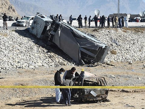 Security officials inspect a burnt out car after a suicide bomb attack targeted a police truck in Quetta on November 30, 2022. 