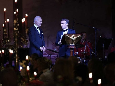 Emmanuel Macron, France's president, right, speaks as US President Joe Biden, listens during a state dinner on the South Lawn of the White House in Washington, DC, US, on Thursday, Dec. 1, 2022. Biden said he wouldn't apologize for a new climate and tax law that European leaders say unfairly subsidize American companies, threatening to overshadow a visit by his French counterpart Macron. 