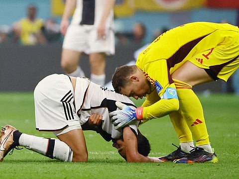 Germany’s captain Manuel Neuer consoles Jamal Musiala after the FIFA World Cup Qatar 2022 Group E match against Costa Rica at the Al Bayt Stadium in Al Khor, Qatar, on December 1, 2022 Germany beat Costa Rica 4-2, but still bowed out of the tournament. 