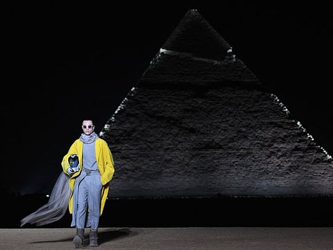 A model presents a creation at the Christian Dior fashion show at the Giza Pyramids Necropolis on the outskirts of the twin city of Egypt's capital on December 3, 2022. - French fashion house Dior today held its first show at Egypt's ancient Giza pyramids, presenting its 2023 fall men's collection in the shadow of the of the millennia-old tombs. (Photo by Ahmed HASAN / AFP)
