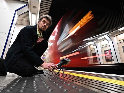Musician and sound artist Stuart Fowkes records the sound of a passing London Underground train at Blackfriars tube station in London on November 28, 2022.  