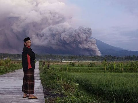 A man looks on as Mount Semeru releases volcanic materials during an eruption on Sunday, Dec. 4, 2022 in Lumajang, East java, Indonesia.