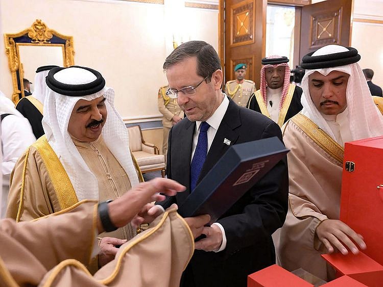 Bahrain's King Hamad bin Isa Al Khalifa receives a gift from Israeli President Isaac Herzog during his visit to Manama.