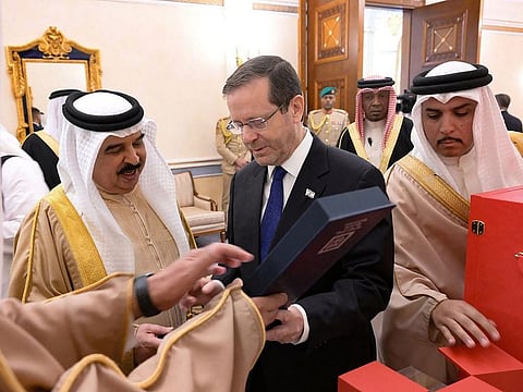 Bahrain's King Hamad bin Isa Al Khalifa receives a gift from Israeli President Isaac Herzog during his visit to Manama.