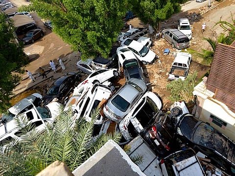 Cars that were washed away by heavy rains are piled up in an alley in the Saudi coastal city of Jeddah on November 25, 2022. At least two people died as heavy rains hit western Saudi Arabia, including the coastal city of Jeddah, delaying flights and forcing schools to close, officials said. 
