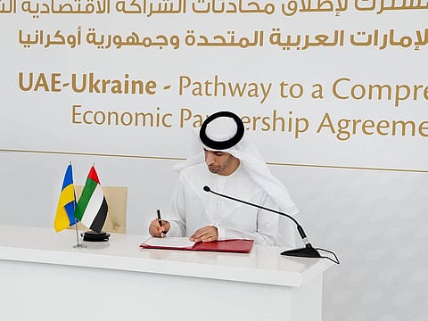 Dr. Thani bin Ahmed Al Zeyoudi, Minister of State for Foreign Trade, signs the agreement.