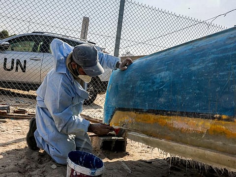 A craftsman uses fibreglass to repair a fishing boat at a workshop supervised by the United Nations at the Gaza seaport on November 29, 2022, after Israel allowed the material to the Palestinian enclave for the first time since 2007 under international supervision.  