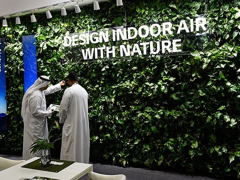 Visitors looking at a sustainable plant wall at a pavilion on the opening day of the Big5 exhibition.