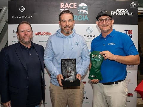 Daniel Van Zyl (centre) winner of the Abu Dhabi Golf Club Qualifier of the Race to Georgia with officials