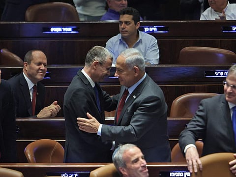 Temporary Knesset (Israeli parliament) speaker Yariv Levin (centre-left) greets prime minister-designate Benjamin Netanyahu during a session to elect the new speaker of the assembly at its Plenum Hall in Jerusalem on December 13, 2022. 
