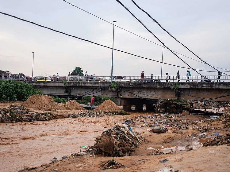 Belongings and debris are washed up by a bridge