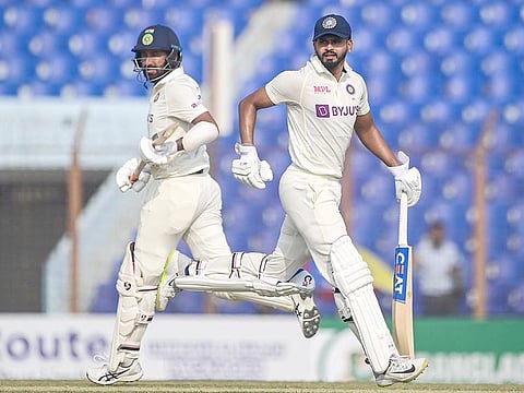 India's Shreyas Iyer (R) and Cheteshwar Pujara run between the wickets during the first day of the first Test match against Bangladesh at the Zahur Ahmed Chowdhury Stadium in Chittagong on December 14, 2022. 