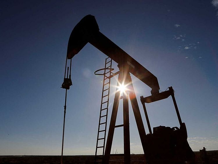 The sun is seen behind a crude oil pump jack in the Permian Basin US