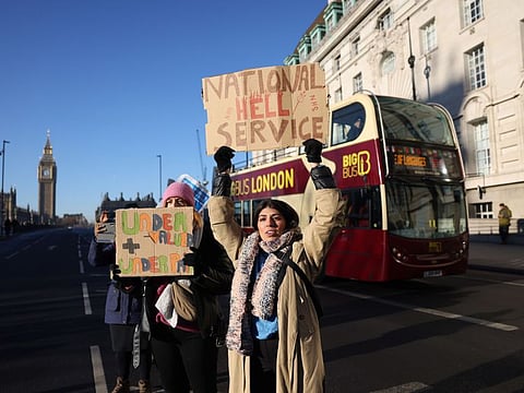 Demonstrators hold placards on a picket line during a strike by NHS nursing staff outside St. Thomas' Hospital in London, on  Dec. 15, 2022.  