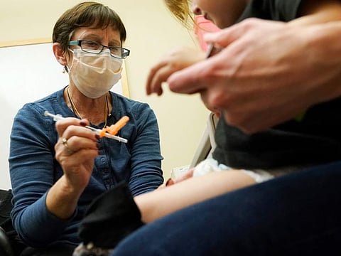 Deborah Sampson, left, a nurse at a University of Washington Medical Center clinic in Seattle, gives a Pfizer COVID-19 vaccine shot to a 20-month-old child, June 21, 2022, in Seattle. The U.S. on Thursday, Dec. 8, 2022 open doses of the updated COVID-19 vaccines for most children younger than age 5. The Food and Drug Administration's decision aims to better protect the littlest kids from severe COVID-19 at a time when children’s hospitals already are packed with tots suffering a variety of other respiratory illnesses, too. (AP Photo/Ted S. Warren, file)