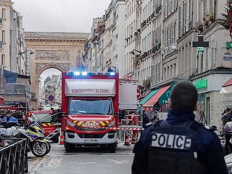 A police officer stands next to the cordoned off area where a shooting took place in Paris, Friday, Dec. 23, 2022.
