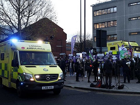 An ambulance on emergency call drives past ambulance workers' strike, amid a dispute with the government over pay, outside NHS London Ambulance Service in London, Britain December 21, 2022. 