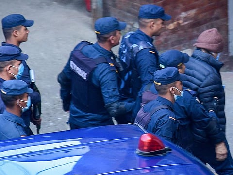 Policemen escort Charles Sobhraj (R) to the immigration office in Kathmandu on December 23, 2022.  