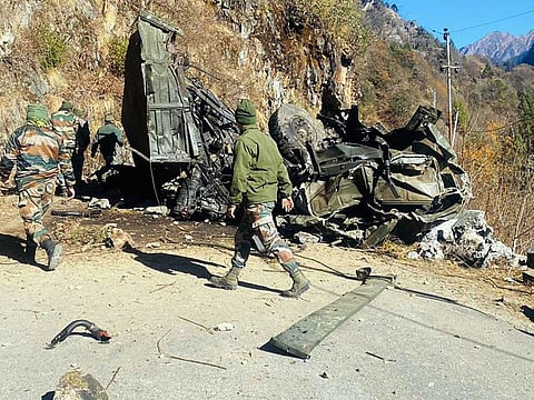 Army personnel seen near the wrecked remains of an Army truck after it lost control and plunged into a steep slope while taking a sharp turn, in the Zema area of North Sikkim on Friday, December 23, 2022.