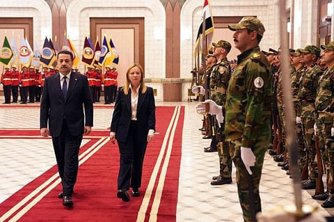A handout picture released by the Iraqi prime minister's office shows Premier Mohamed Shia al-Sudani reviewing an honour guard with his Italian counterpart Giorgia Meloni at the government's seat in the capital Baghdad at the start of her official visit to Iraq on December 23, 2022.