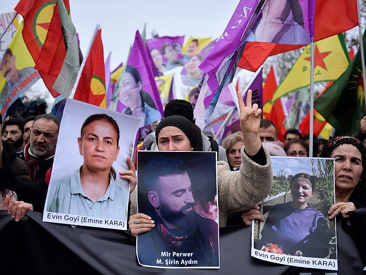 Supporters and members of the Kurdish community hold portraits of victims Emine Kara and Mir Perwer during a demonstration a day after a gunman opened fire at a Kurdish cultural centre killing three people, at The Place de la Republique in Paris on December 24, 2022.