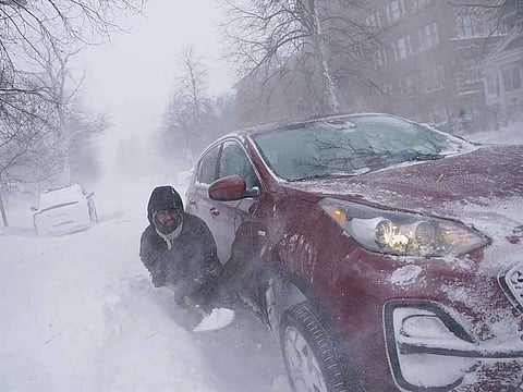 Gamaliel Vega tries to dig out his car on Lafayette Avenue after he got stuck in a snowdrift about a block from home while trying to help rescue his cousin, who had lost power and heat with a baby at home across town during a blizzard in Buffalo on Saturday, December 24, 2022. 