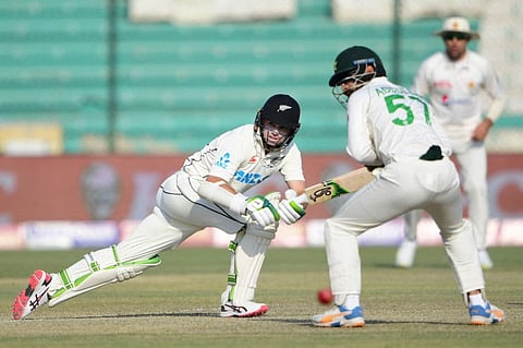 New Zealand's Tom Latham (left) plays a shot as Pakistan's Abdullah Shafique (centre) watches during the second day of the first Test at the National Stadium in Karachi.