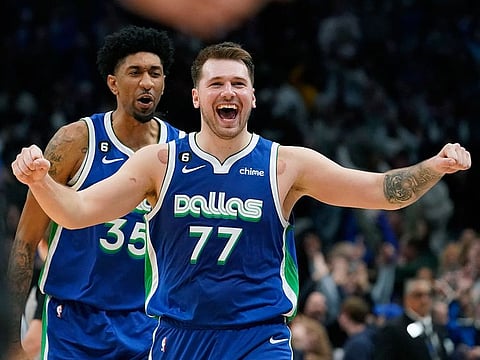 Dallas Mavericks guard Luka Doncic (77) celebrates scoring the game tying basket in front of teammate Christian Wood (35) during the fourth quarter of an NBA basketball game against the New York Knicks in Dallas.
