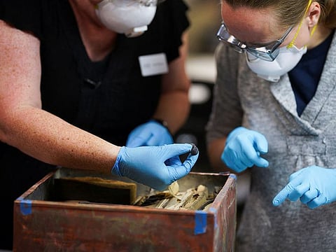 Conservators Kate Ridgway and Sue Donovan remove a bullet found in a time capsule recovered from Confederate General Robert E. Lee's monument in Richmond, Virginia, U.S., December 28, 2021. 