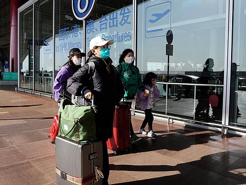 Passengers wearing masks walk through the Capital airport terminal in Beijing.