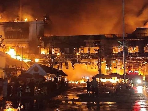 Firefighters and rescue workers gather at the site of a fire at the Grand Diamond City hotel-casino in Poipet.
