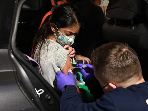 A San Ramon Valley Fire District worker administers a COVID-19 vaccine to an 11-year-old in San Ramon, California..
