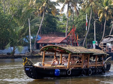 A small traditional Indian boat takes a group of young western tourists on a cruise on the Alleppey backwaters in the southern state of Kerala.