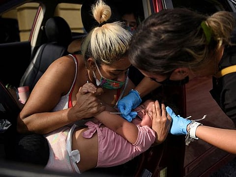 A healthcare worker tests a child for the coronavirus at a drive-through testing site as the Omicron variant continues to spread through the country in Houston, Texas.