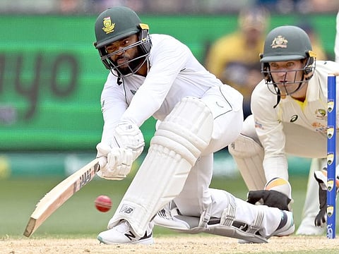 South Africa's Temba Bavuma sweeps a delivery as Australia's wicketkeeper Alex Carey (R) looks on on the fourth day of the second Test match at the MCG in Melbourne on December 29, 2022. 
