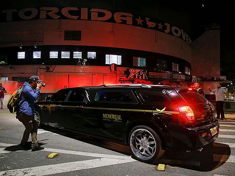 A man takes a picture of the vehicle transporting Brazilian soccer legend Pele's body, at the Vila Belmiro stadium in Santos, Brazil.
