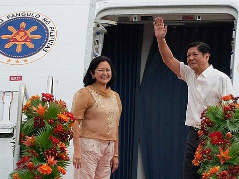 Philippine President Ferdinand Marcos Jr., right, waves beside wife Maria Louise as they board a plane for China on Tuesday, Jan. 3, 2023, at the Villamor Air Base in Manila, Philippines. 