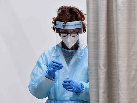 A health worker wearing personal protective equipment (PPE) places a coronavirus disease (COVID-19) test swab in a vial, after Italy has ordered COVID-19 antigen swabs and virus sequencing for all travellers coming from China, where cases are surging, at the Malpensa Airport in Milan, Italy, December 29, 2022. 