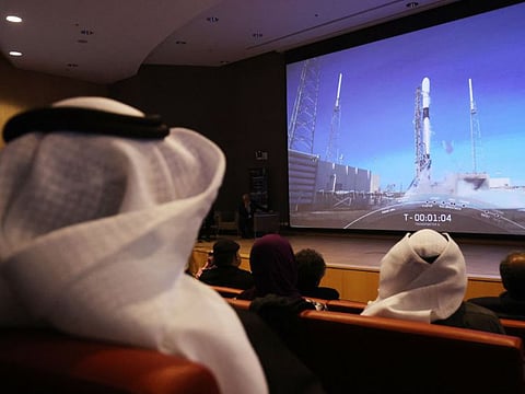 Kuwaitis watch a screen displaying a live footage of the first Kuwaiti Satellite (Kuwait Sat-1) launching from Florida, at Kuwait university on January 3, 2023. 