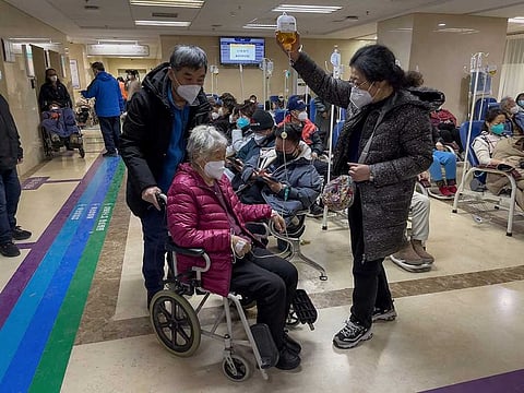 An elderly patient is pushed along a corridor of the emergency ward providing intravenous drips Tuesday, Jan. 3, 2023. As the virus continues to rip through China, global organisations and governments have called on the country start sharing data.