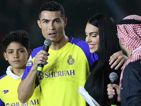Portuguese forward Cristiano Ronaldo (C-L), accompanied by his partner Georgina Rodriguez (C-R) and his son Cristiano Ronaldo Jr, greets the crowd at the Mrsool Park Stadium in the Saudi capital Riyadh on January 3, 2023, upon his presentation as an Al Nassr player. 