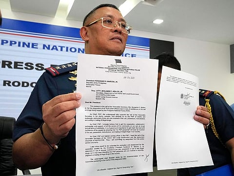 Philippine Police Chief, Police Gen. Rodolfo Azurin Jr., holds a letter showing his courtesy resignation during a news conference.