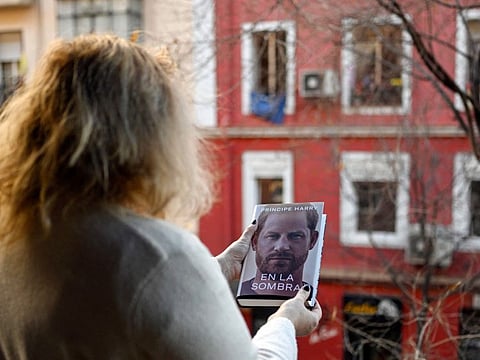 A woman leafs holds the "En la sombra" (In the shadow) Spanish version of the book "Spare" an autbiography by Britain's Prince Harry after buying it in Madrid on January 5, 2023, despite the publication date set at January 10 with stringent measures in place. 