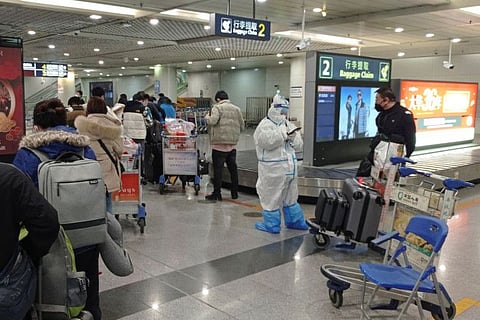 Passengers arriving on international flights wait in line at the airport in Chengdu, on January 6, 2023. 