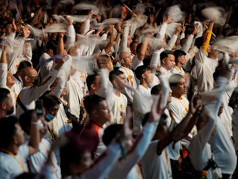 Devotees wave their towels as they join in the "Walk of Faith" procession as part of celebrations for the feast day of the Black Nazarene, a centuries-old charred statue of Jesus Christ, on Sunday, Jan. 8, 2023, in Manila, Philippines.