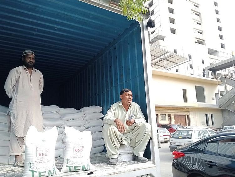 A trailer in Karachi providing wheat flour bags at discounted rate.