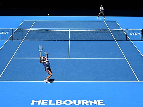 Poland's Iga Swiatek (bottom L) serves to Madison Keys of the US (top R) during a practice session ahead of the Australian Open tennis tournament in Melbourne.